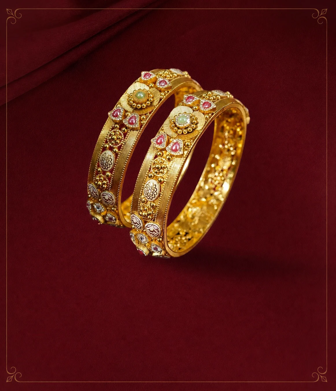 Set of classic carved gold bangles stacked on a maroon surface