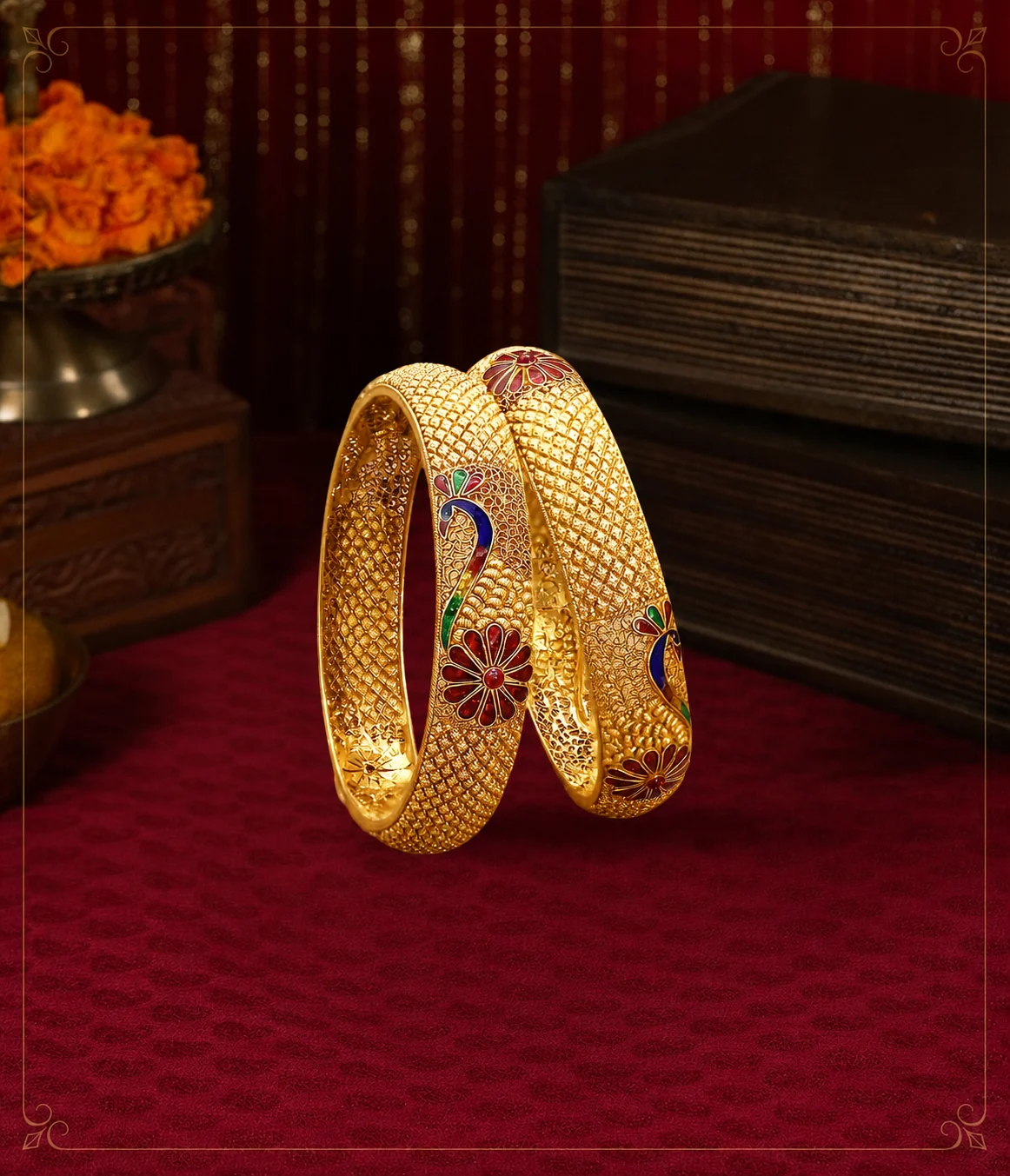 Pair of gold bangles with peacock motifs on a maroon backdrop